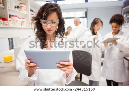 Science student looking at tablet pc in the lab at the university
