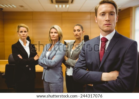 Serious lawyer standing with arms crossed in the court room