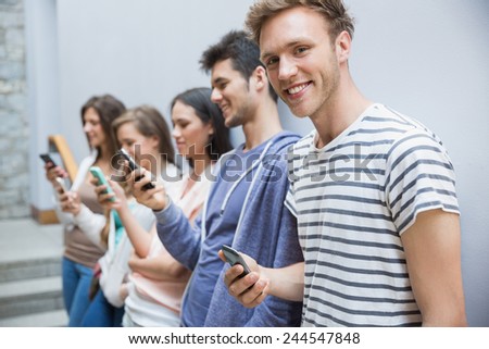 Students using their smartphones in a row at the university
