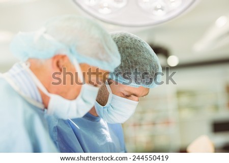 Older surgeon teaching new surgeon how to operate at the university
