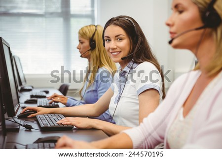 Smiling call centre agent talking on the headset in the office