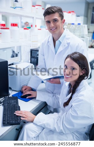 Chemist team working together at desk using computer in the laboratory