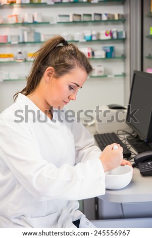 Junior pharmacist mixing a medicine at the hospital pharmacy