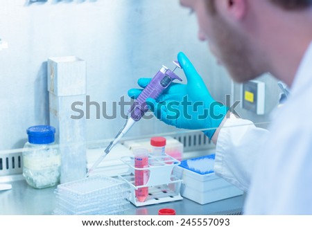 Science student using pipette in the lab at the university