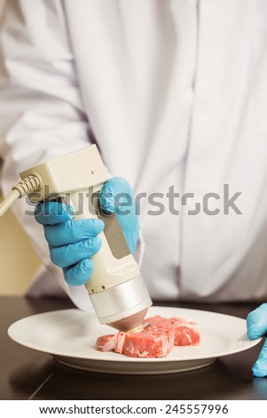 Food scientist using device on meat at the university