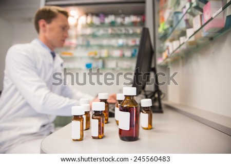 Pharmacist using computer at desk at the hospital pharmacy
