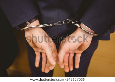 Hands of businessman with handcuffs in the court room