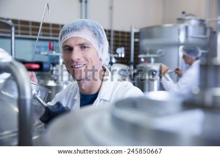 Close up of a man wearing a hair net looking at the camera in the factory