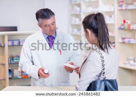 Customer handing a prescription to a pharmacist in the pharmacy