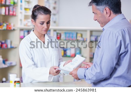 Customer handing a prescription to a trainee in the pharmacy