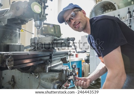 Engineering student using large drill at the university