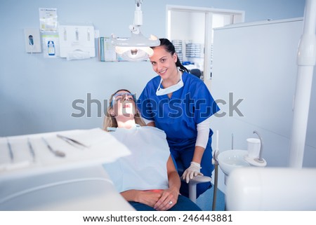 Dentist sitting over patient in the chair at the dental clinic