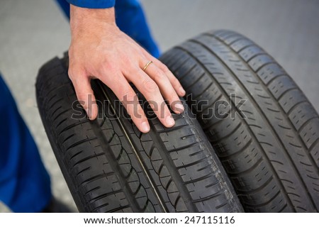 Mechanic rolling a tire wheel at the repair garage