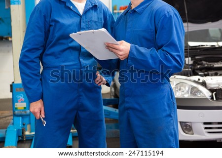 Team of mechanics talking together at the repair garage