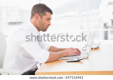 Focused businessman working on his laptop on white background