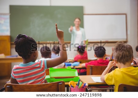 Pupils raising their hands during class at the elementary school