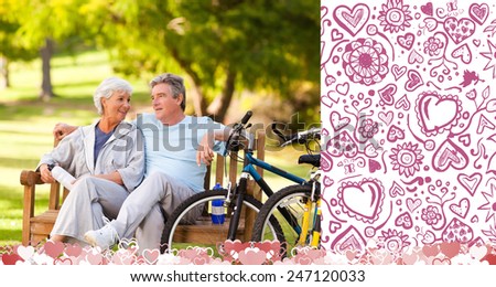 Elderly couple with their bikes against valentines pattern