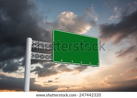 Green billboard sign against blue and orange sky with clouds