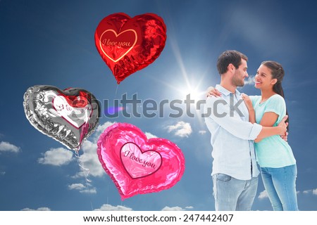 Attractive young couple hugging each other against cloudy sky with sunshine