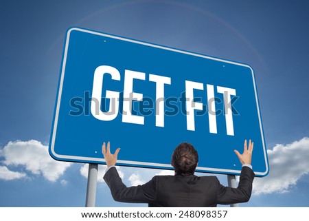 The word get fit and gesturing businessman against cloudy sky with sunshine