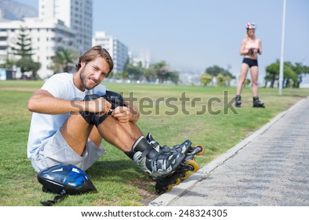 Fit man getting ready to roller blade on a sunny day