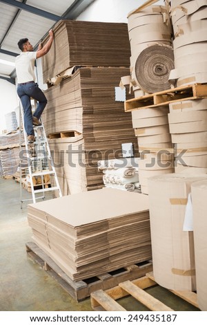 Full length of a warehouse worker loading up pallet