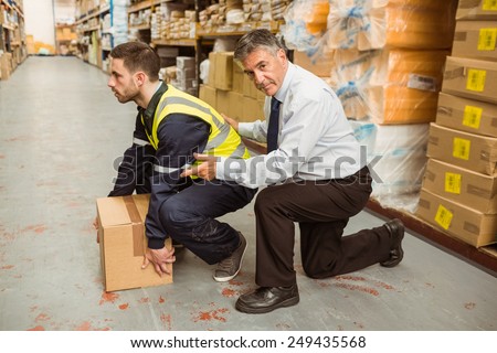 Manager training worker for health and safety measure in a large warehouse