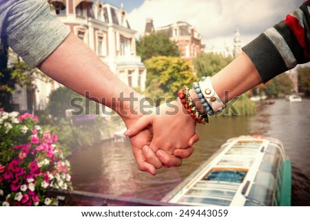Students holding hands against canal in amsterdam