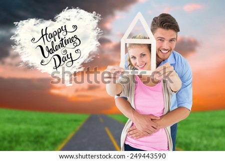 Young couple hugging and holding house outline against cloud heart