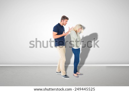 Young couple having an argument against grey room