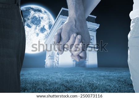 Happy senior couple holding hands against bright moon over arc de triomph