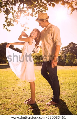 Cute couple dancing in the park and laughing on a sunny day