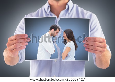Angry couple facing off after argument against grey vignette