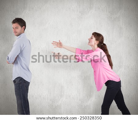Woman trying to hug man against weathered surface
