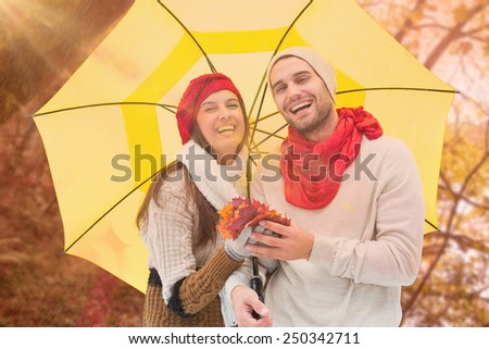 Autumn couple holding umbrella against tranquil autumn scene in forest