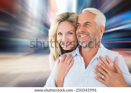 Smiling couple embracing with woman looking at camera against blurry new york street