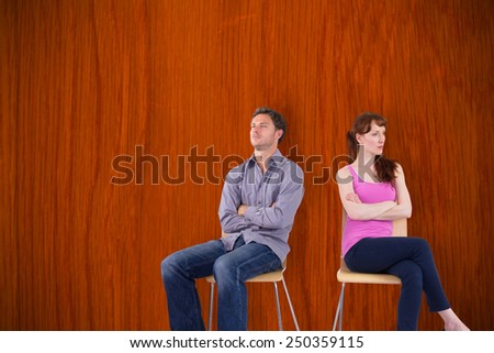 Sitting couple ignoring each other against wooden oak table