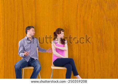 Sitting couple having an argument against wooden pine table