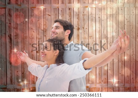 Cute couple standing with arms out against light design shimmering on red