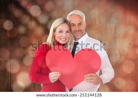 Handsome man getting a heart card form wife against light circles on black background