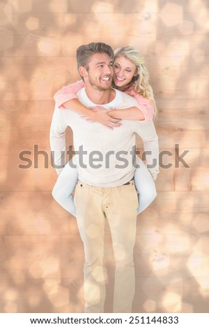 Handsome man giving piggy back to his girlfriend against light glowing dots design pattern