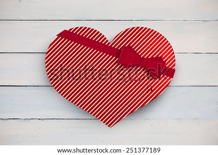 Heart shaped box of candy against painted blue wooden planks