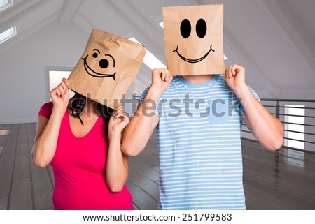 Young couple with bags over heads against white room with open door