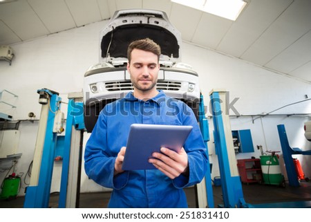 Mechanic using a tablet pc at the repair garage