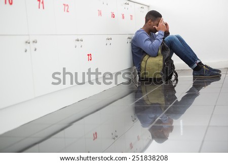 University student sitting alone with his hands on face at the university