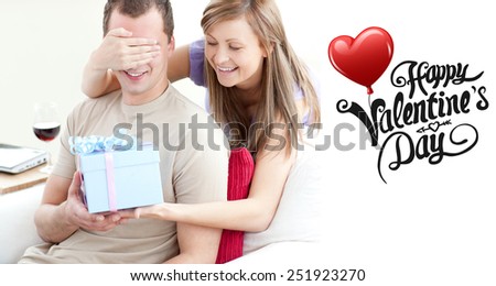 Smiling woman giving a present to her boyfriend against cute valentines message