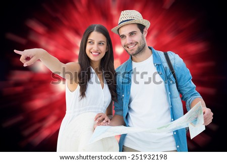 Happy hipster couple looking at map against valentines heart design