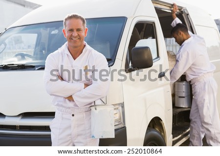 Painter smiling leaning against his van outside the warehouse