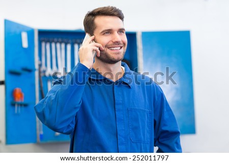 Smiling mechanic on the phone at the repair garage