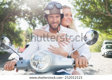 Attractive couple with their scooter on a sunny day in the city